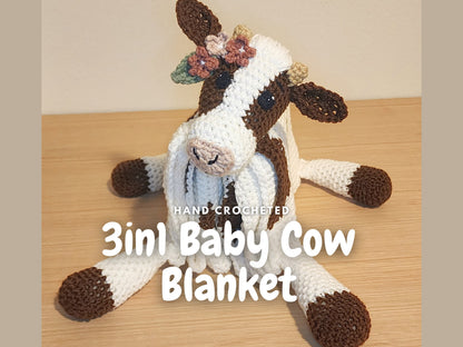 Close-up of a crochet cow plush blanket featuring flowers in the cows ear as a yarn detail