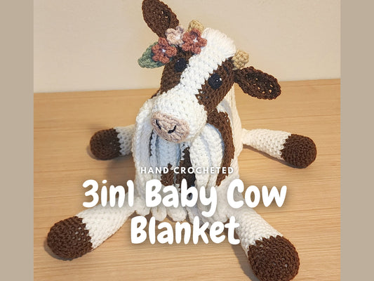 Close-up of a crochet cow plush blanket featuring flowers in the cows ear as a yarn detail