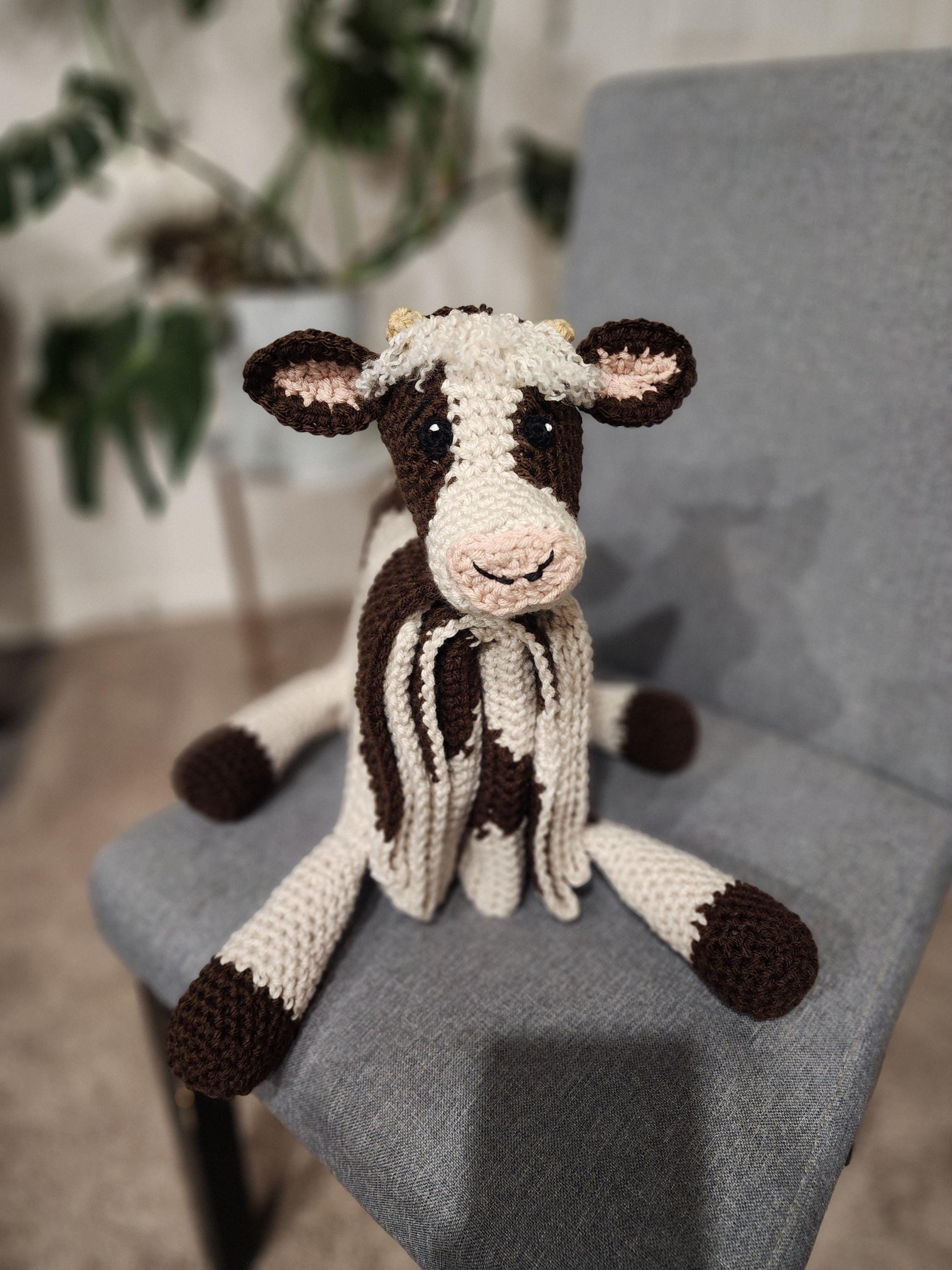 Close-up of a crochet cow plush blanket featuring "crazy hair" yarn detail 